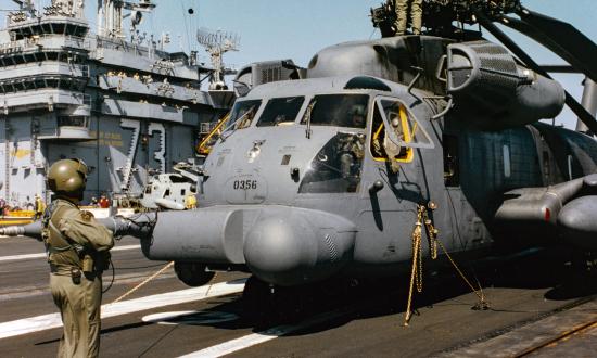 Crewmembers from the 20th Special Operations Squadron complete tiedown of their MH-53 on the flight deck of the USS George Washington CVN 73 during joint operation exercises