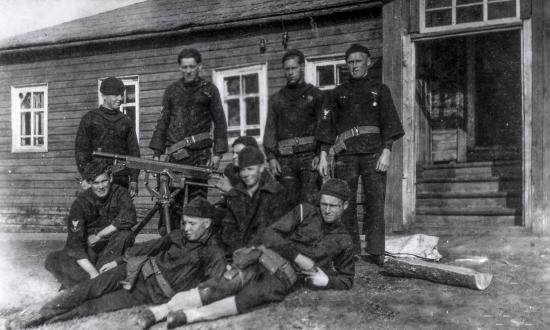 Sailors posing outside a hut with a 30-calibre machine gun during the Russian Intervention