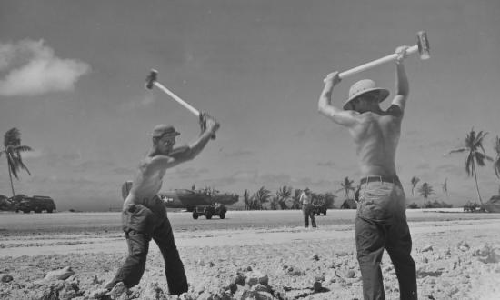 Seabees hammer lumps of coral into sand to enlarge the runway on the Eniwetok atoll.