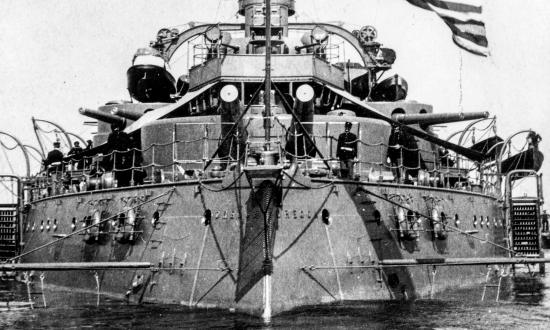 Stern-on view of the battleship Oregon (BB-3) at anchor with boat booms extended