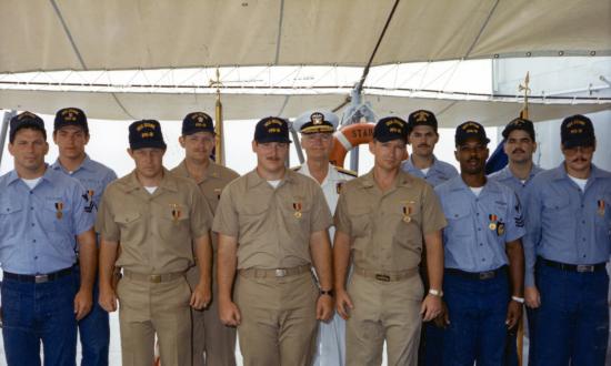 en crew members of the USS Stark (FFG-31) pose for a group photo after receiving the Navy and Marine Corps Medal for heroism.