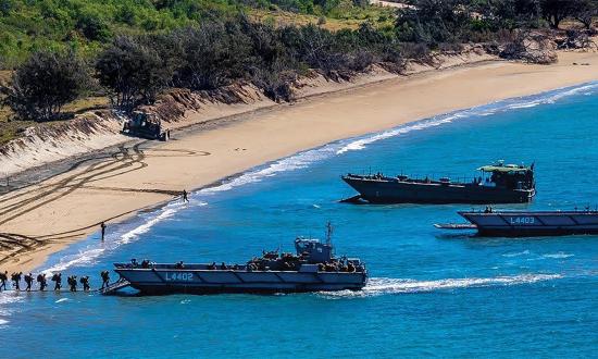 U.S. Marines and soldiers from 3rd Royal Australian Regiment load onto landing craft at King Beach in Bowen, Australia. This is the type of site at which a temporary expedient naval facility could be constructed.