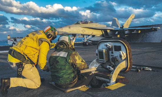 Sailors aboard the aircraft carrier USS Ronald Reagan (CVN 76) monitor the pitch of the ship prior to launching an  F/A-18F Super Horne