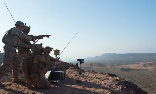 : U.S. Marines and Army soldiers watch 120mm mortar rounds hit the target during a joint training exercise at a range near Camp Lemonnier, Djibouti.