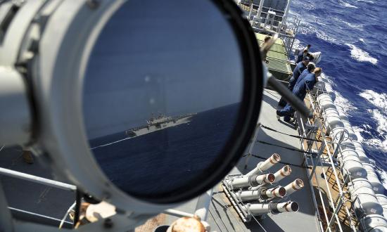 A U.S. Navy LHD reflected in the signal lamp of the USS Ponce.