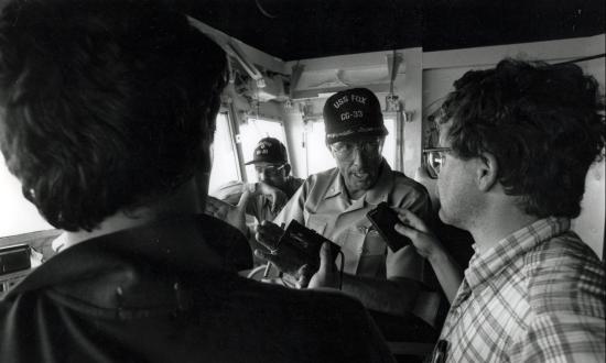 CAPT William Mathis, USN, of the USS Fox (CG033) being interviewed on the bridge