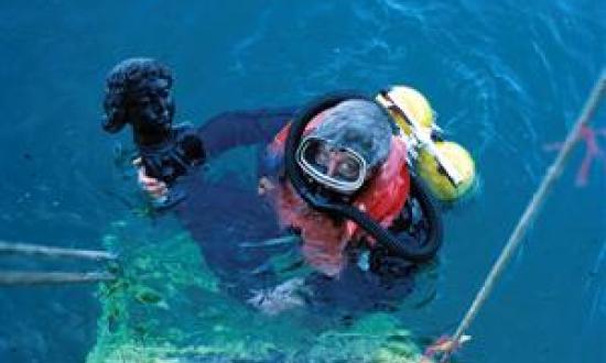 A diver recovers the head of a statue from the 1697 wreck of the Santo Antonio da Tanna off Mombasa, Kenya. The Institute of Nautical Archaeology helped oversee the site's excavation.